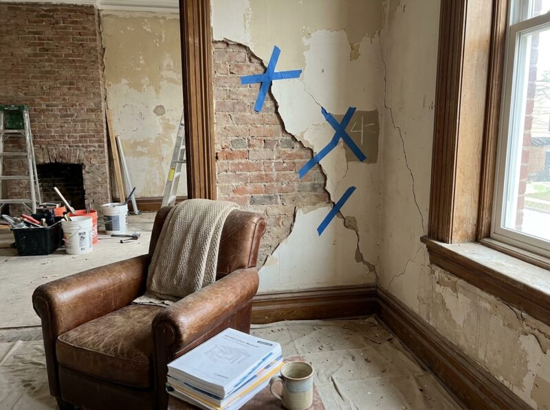 Scheuren in de muur: welke onschuldig zijn en welke niet Trapsgewijze scheur die de voegen volgt in een bakstenen gevel van een vooroorlogse woning