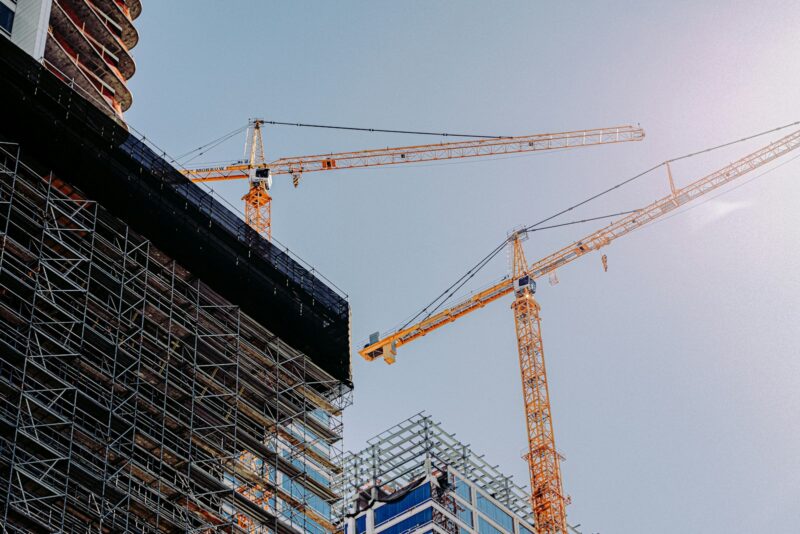 Inflatie loopt op: worden bouwmaterialen en je aannemer nu ook duurder? Pallets met bouwmaterialen en gipsplaten in een woning in verbouwing