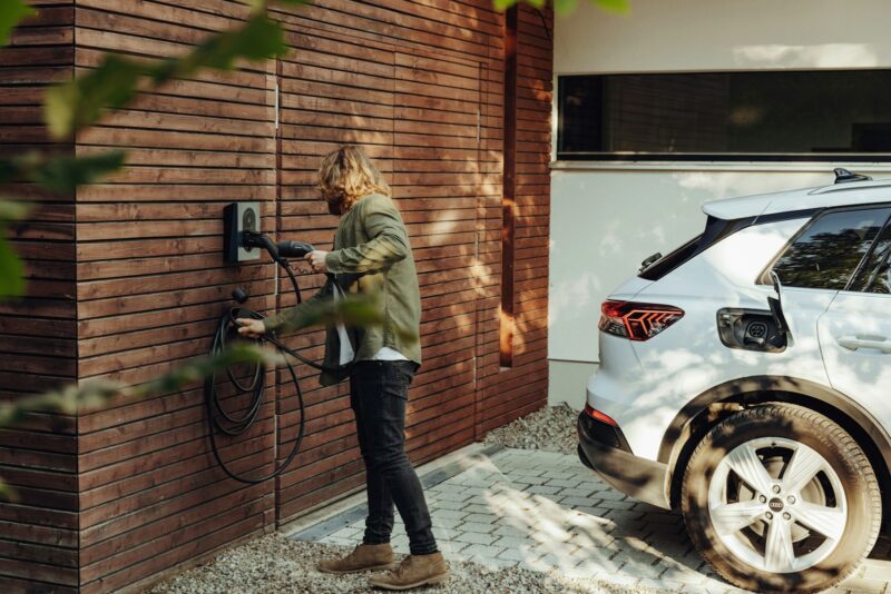 Laadpaal bij je huis laten plaatsen: wat je meterkast en oprit nodig hebben Laadpaal aan de gevel van een woning met een elektrische auto op de oprit