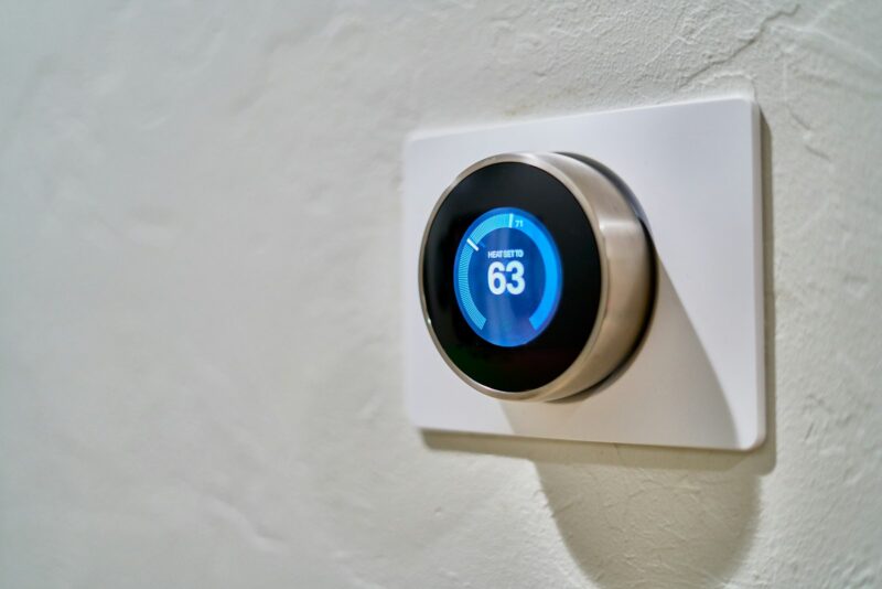 Slim huis gekocht? Zo haal je de vorige bewoner uit je apparaten Slimme thermostaat aan de muur in een woonkamer