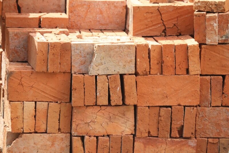 Stempel op een plank hout: wat hij je vertelt voordat je gaat klussen Gestapelde vurenhouten balken in een houthandel