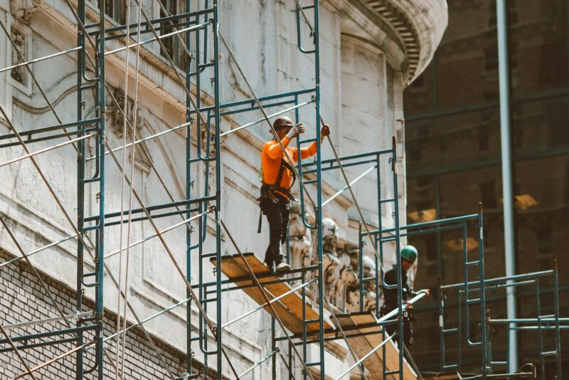 Je VvE wil verduurzamen: wat als je jouw aandeel niet kunt betalen Appartementencomplex met steigers voor een renovatie van de gevel